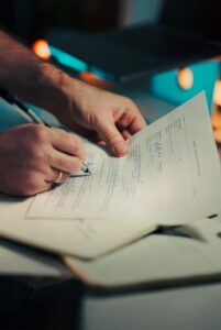 Mãos assinando contrato de cessão de marca em escritório