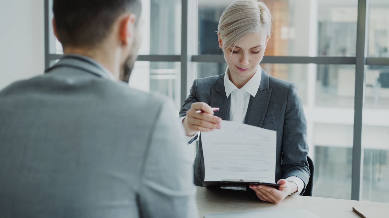 Executivos revisando contrato e portfólio de marcas de uma empresa